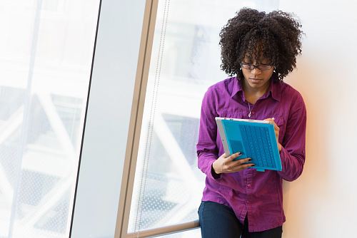 woman in purple dress shirt using laptop